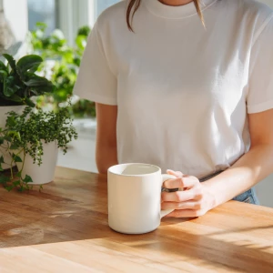 A minimalist bright kitchen scene with a woman in a white t-shir...