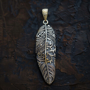 A feather pendant featuring an intricate Indian design engraved...