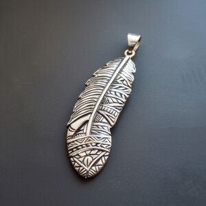 Sterling silver feather pendant featuring intricate Aztec design...