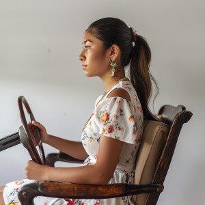 A cute Mexican woman sitting in a wooden chair
Brown ponytail...