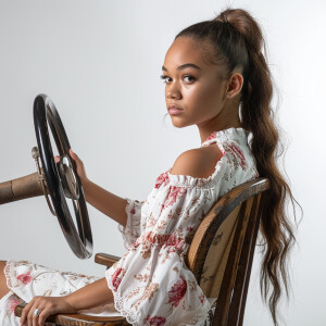 A cute Blasian woman sitting in a wooden chair
Brown ponytail...