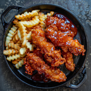 Generate an image of six pieces of crispy fried chicken tenders...