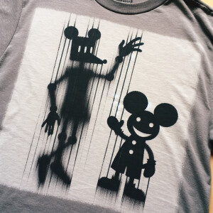 a gray t-shirt with a unique graphic design. The design showcase...