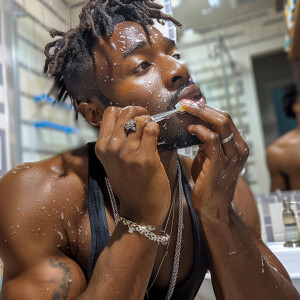 Me a black  man in bathroom washing my face and brushing teeth a...