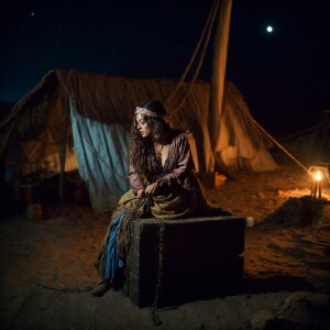 A Wench clothes torn, squatting,  chained over a breading  block...