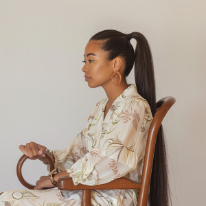 A cute Blasian woman sitting in a wooden chair
Brown ponytail...