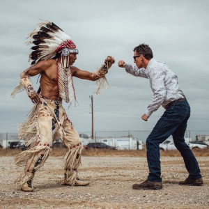 Native American man wearing traditional regalia with buckskin pa...
