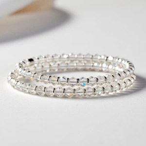 "A sophisticated wrap bracelet combining clear crystals with sil...