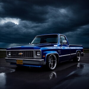 1983 Chevrolet C10 lowrider with a glossy, reflective deep blue...