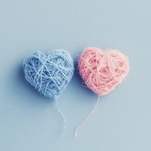 Two hearts connected by tangled string, soft colors, symbolic an...