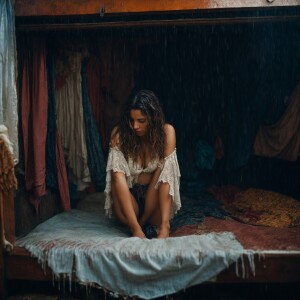 A shamed cheating Wench clothes torn, squatting beside a bed at...