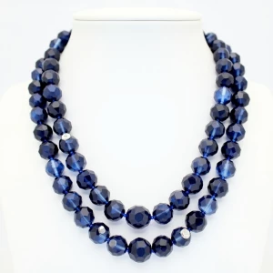 A sophisticated double-strand necklace combining deep blue facet...