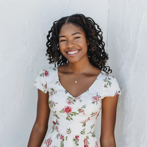 A cute woman

Smiling 

Clothes: White Floral Dress

Looks Clean...