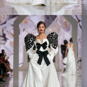 A beautiful woman walks down a white runway in a dramatic white...