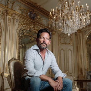 A man in his 50s with short dark hair and a neatly trimmed beard...