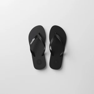 Create a minimalist flat lay composition with a pair black flip...
