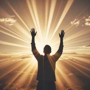 A silhouette of a person worshiping with raised hands, standing...