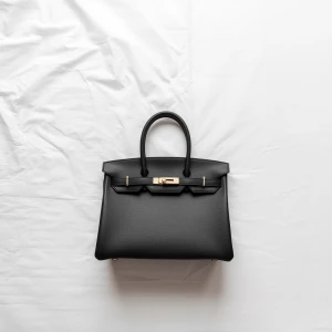 Create a minimalist flat lay composition with a black structured...