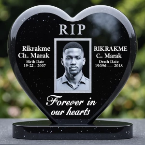 A heart-shaped black granite headstone with a smooth, reflective...