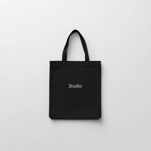 Create a minimalist flat lay composition with a black bag laid o...