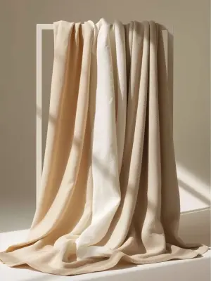 editorial studio photograph of layered cotton and linen fabrics...