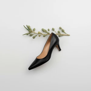 Create a minimalist flat lay composition with a classic black pu...