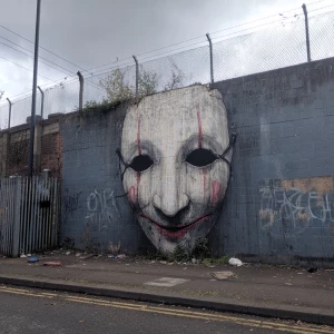 Horror themed giant mask on a wall Banksy style.