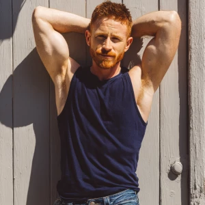 A 35-year-old, muscular, fair-skinned man with short natural red...