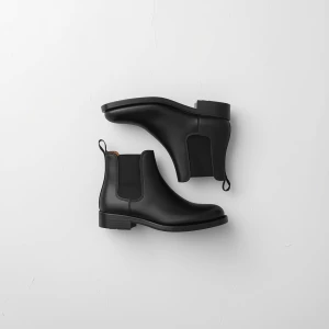 Create a minimalist flat lay composition with a pair of  black b...