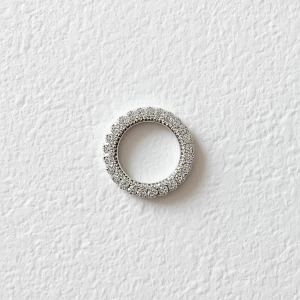 Create elaborate ring displayed on a pristine, textured white su...