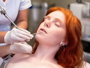 A redhead getting her nipples pierced at a professional piercing...