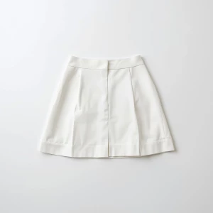 Create a minimalist flat lay composition with a classic white kn...