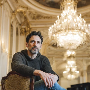 A man in his 50s with short dark hair and a neatly trimmed beard...