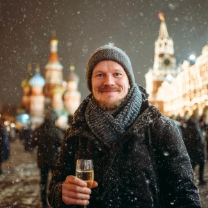 A man standing on Moscow Red square, holding a sparkling glass o...