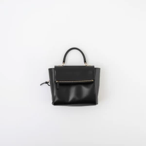 Create a minimalist flat lay composition with a black handbag la...