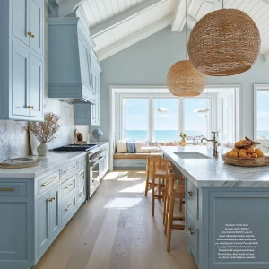 “Bright coastal-style kitchen with soft blue shaker cabinets, wh...