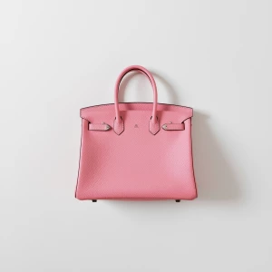 Create a minimalist flat lay composition with a pink structured...