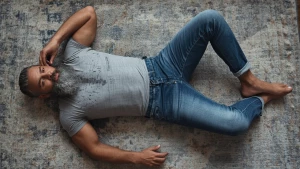 a gray muscle man hairy chest beard with gray hair, jeans laying...