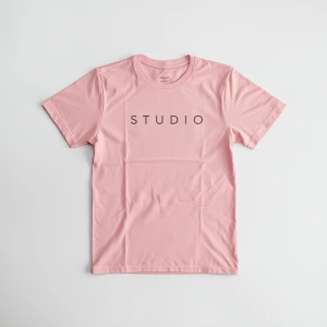 Create a minimalist flat lay composition with a pink t-shirt lai...